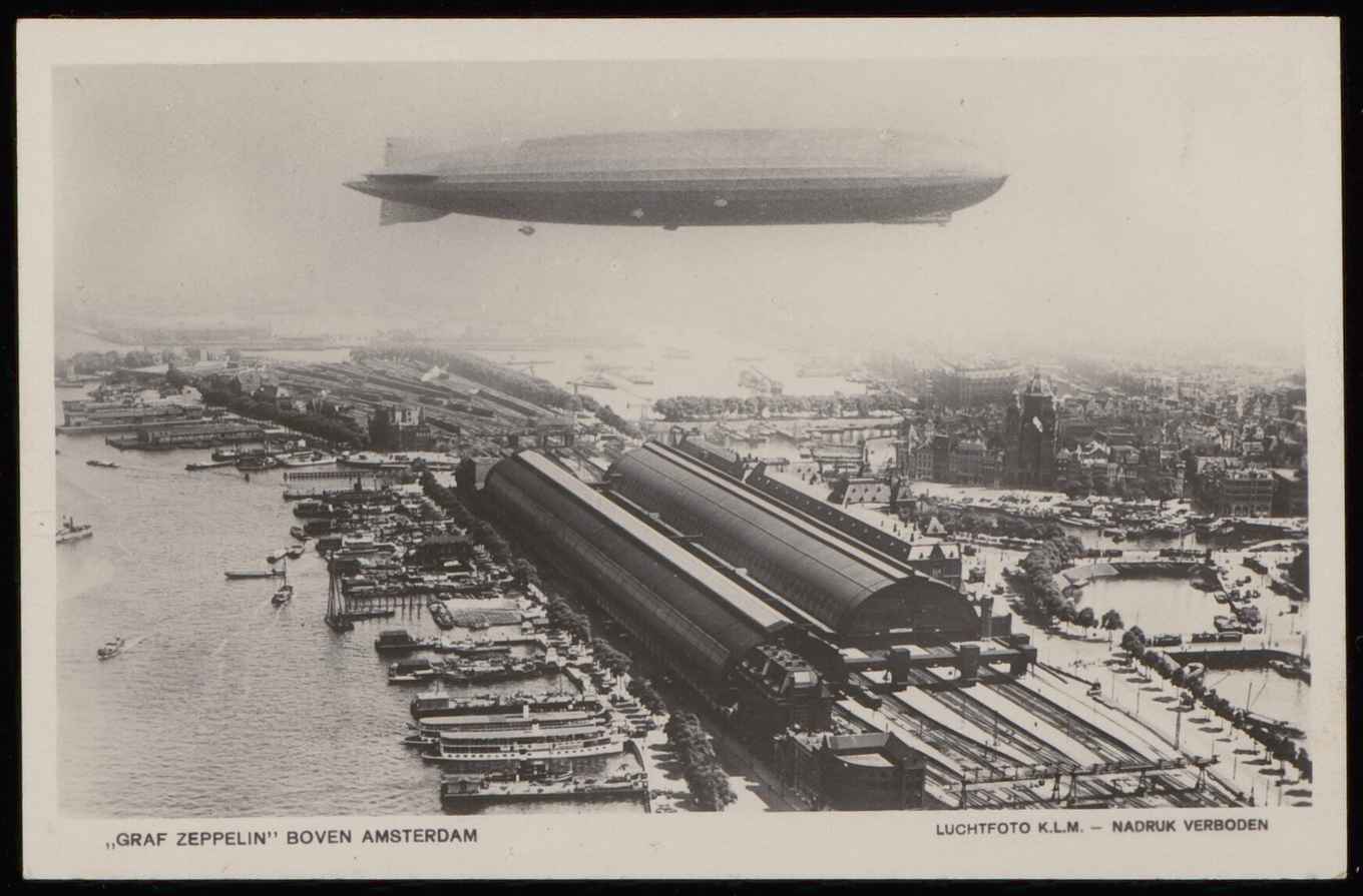 1924 Graf Zeppelin hangt boven het Centraal Station van Amsterdam, luchtfoto KLM